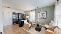 This three-story home offers a well-organized layout across its floors, with light hardwood flooring and a crisp white interior palette maintained consistently throughout. The entry level features a welcoming foyer with a staircase finished in warm wood treads and white risers with a wood handrail, providing an immediately clean and modern first impression.

The main living floor hosts an open-concept kitchen and living area flooded with natural light from multiple windows. The kitchen is equipped with white shaker-style cabinetry, granite countertops, a tile backsplash, stainless steel appliances including a side-by-side refrigerator, and a central island with pendant lighting overhead. A door provides direct outdoor access from this level.

The upper floors accommodate four bedrooms, including a generously sized primary bedroom featuring a ceiling fan, natural light from dual windows, and direct access to a private bathroom. Additional bedrooms are well-proportioned with closets and access to hallway bathrooms. All four bathrooms maintain a uniform clean design with white vanities, wood-toned flooring, and shower-tub combinations. Two hallways connect the bedrooms across the upper floors, ensuring efficient circulation throughout the home.