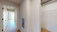 Located at 50 E Fillmore St in Phoenix, AZ, this contemporary 3-bedroom, 2-bathroom high-rise unit delivers an urban living experience defined by striking industrial-modern design. Exposed concrete ceilings contrast beautifully with crisp white walls and warm light wood flooring found throughout the residence. Floor-to-ceiling windows flood every room with abundant natural light while framing panoramic views of the Phoenix skyline and surrounding cityscape. The open-concept kitchen and living area serves as the heart of the home, featuring a large central island with pendant globe lighting, sleek white flat-front cabinetry, a tiled backsplash, and a full suite of stainless steel appliances. A balcony extends the living space outdoors. Each of the three bedrooms is generously proportioned, with large windows showcasing elevated city views; the spacious primary bedroom includes ample closet space. The two bathrooms are finished with large-format tile flooring, full-height wall tile, warm wood vanities, dual sinks, and matte black fixtures. A dedicated laundry room houses a stacked washer and dryer unit. Four closets provide excellent storage throughout. The layout is efficient and well-organized, connected by a central hallway, making this an ideal residence in the heart of Phoenix.