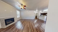 Located at 5300 Antequera Rd NW in Albuquerque, New Mexico, this single-story, 3-bedroom, 2-bathroom home offers a well-designed layout with a comfortable and functional living experience. The spacious living room is a standout feature, showcasing rich hardwood-style flooring, crown molding, a ceiling fan, and a granite-surround fireplace that serves as an elegant focal point. Natural light filters in through multiple windows, creating a bright and welcoming atmosphere throughout. The adjacent dining area continues the hardwood-style flooring and is appointed with a stylish chandelier, complemented by a large window with outdoor views. The kitchen is well-equipped with dark espresso cabinetry extending to the upper walls, granite countertops, and stainless steel appliances including a refrigerator, range, and over-the-range microwave. Arched architectural details connect the main living spaces, adding a touch of character. The three bedrooms feature plush carpeting and generous proportions, with the primary bedroom offering a walk-in closet complete with built-in wire shelving. The bathrooms are finished with granite-topped dark vanities and hardwood-style flooring. A dedicated laundry area with hookups adds everyday convenience to this well-appointed Albuquerque home.