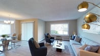 Prospect Pointe presents a thoughtfully designed single-floor residence with a warm, neutral color palette and wood-style flooring throughout the main living areas. The inviting living room is anchored by a large picture window that draws in natural light and offers views of surrounding greenery, complemented by a vertical blind-covered sliding door. A wall-unit air conditioner and baseboard heating ensure year-round comfort.

The kitchen features white cabinetry, stainless steel appliances including a refrigerator, range, and built-in microwave, along with laminate countertops and a window overlooking the outdoors. Adjacent to the kitchen, the dining area is illuminated by a modern chandelier and provides an ideal setting for entertaining.

The bedrooms are carpeted for comfort, with the primary bedroom offering dual closets with sliding doors and a bright window. A secondary bedroom serves well as a home office or guest room, also featuring natural light and baseboard heating. The bathrooms are clean and functional, with one featuring a white vanity, framed mirror, and lighted fixtures. The entryway leads seamlessly into the living space, tying together the home's cohesive and comfortable design.
