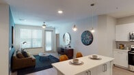 This single-story residence is thoughtfully designed with a modern, open-concept layout that promotes a seamless flow between the kitchen, dining, and living areas. The kitchen is outfitted with crisp white cabinetry, light quartz countertops, stainless steel appliances including a side-by-side refrigerator, and a central island with pendant lighting overhead—ideal for casual dining or entertaining. Light wood-style flooring runs throughout the main living areas, while large windows fitted with horizontal blinds allow natural light to fill the space. A ceiling fan services the living room, which connects to a dining nook and offers access to an outdoor area.

The residence includes multiple bedrooms, each carpeted and equipped with ceiling fans. The primary bedroom is generously sized, featuring ample natural light and direct access to a private bathroom. The bathrooms are finished with tile flooring, white vanities, and large mirrors. One bathroom features a soaking tub with large-format tile surround. Additional storage is provided throughout via louvered-door closets. The overall aesthetic is clean and contemporary, with neutral tones creating a calm, cohesive ambiance throughout.