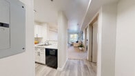 Located at 11030 Evergreen Way in Everett, WA, this one-bedroom, one-bathroom residence offers a well-planned layout across a single floor, making efficient use of every square foot. The kitchen features white shaker cabinetry, a marble-style countertop, and a black dishwasher, seamlessly connecting to the main living area via light wood-look flooring. The living room is bright and welcoming, with plush carpet, neutral walls, and a sliding glass door that opens to an outdoor balcony, allowing natural light to fill the space and providing views of the surrounding greenery. The bedroom is a comfortable retreat with soft carpeting, a large window overlooking outdoor landscaping, and a closet for storage. The bathroom is finished with a white vanity, marble-look countertop, black hardware, and wood-look flooring, complemented by open shelving for added convenience. A dedicated in-unit laundry area houses a full-size side-by-side washer and dryer with overhead shelving for storage. Clean lines, a neutral color palette, and consistent modern finishes throughout create a cohesive and functional living environment in this Everett residence.