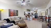 Located at 1710 S Salem Rd in Conway, Arkansas, this one-bedroom, one-bathroom unit offers a practical and well-designed layout across a single floor. The open-concept living and kitchen area forms the heart of the space, where vaulted ceilings lend a sense of airiness well beyond the physical footprint. The living room features soft carpet, a ceiling fan with integrated lighting, and a front-facing window that allows natural light to fill the room. The kitchen is efficiently designed with white cabinetry, dark granite countertop surfaces, black appliances including a refrigerator, range, and microwave, and a breakfast bar with bar seating — ideal for casual dining. Tile flooring runs throughout the kitchen and dining area, which accommodates a full dining table. The bedroom is a comfortable retreat with plush carpet, a ceiling fan, and a window offering outdoor views. A dedicated closet provides practical storage. The bathroom features tile flooring, a vanity with white cabinetry, a large mirror, and overhead lighting. Throughout the unit, the warm neutral palette and consistent design choices create a cohesive and inviting atmosphere.