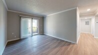 Located in Saint Petersburg, FL, this 2-bedroom, 2-bathroom residence offers a thoughtfully designed single-floor layout with a clean, modern aesthetic throughout. Wood-look plank flooring flows seamlessly across all living areas, complemented by neutral gray tones, textured ceilings, and crisp white trim that create a bright and cohesive ambiance.

The living room is a comfortable, open space featuring crown molding and a sliding glass door that invites natural light and provides outdoor access. The galley-style kitchen is well-equipped with white shaker cabinetry, light quartz countertops, a classic tile backsplash, and a full suite of stainless steel appliances, including a refrigerator, electric range, microwave, and dishwasher.

Both bedrooms are well-proportioned, featuring neutral walls, wood-look flooring, and windows fitted with blinds that allow for controlled natural light. The primary bedroom includes a dedicated walk-in closet with wire shelving for organized storage.

The two bathrooms are finished in a clean, contemporary style. One features a soaking tub with marble-look tile surround and brushed gold fixtures, while the other offers a white vanity with ample cabinetry and modern lighting. A hallway and entrance area complete the efficient and functional floor plan.