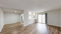 Located at 4061 Eagles Roost Dr in Indianapolis, Indiana, this single-floor, 2-bedroom, 2-bathroom home offers a well-designed layout with a comfortable blend of functionality and style. The open living and dining area features wood-look flooring and a textured ceiling, with a sliding glass door that fills the space with natural light and provides direct access to a private outdoor deck. The kitchen is efficiently arranged with ample white cabinetry, a stainless steel refrigerator, a dishwasher, a skylight, and a dedicated exterior door for added convenience. A pass-through counter connects the kitchen to the living area, creating an open feel. The home includes a den, ideal for a home office or flex space, along with a dedicated laundry area. Both bedrooms are carpeted and generously sized, with the primary bedroom offering a spacious walk-in closet. The two bathrooms are clean and functional — one features a full tub/shower combo, while the other includes a wide vanity with extended countertop storage and wood-look tile flooring. Four closets throughout the home provide abundant storage. A wide hallway with louvered closet doors connects the living spaces to the bedrooms, adding to the home's practical flow.
