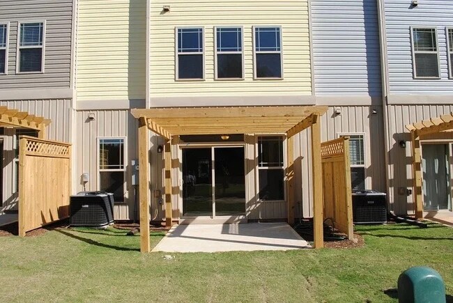 Patio con vistas a una zona común con pérgola, árboles, senderos verdes y un pintoresco estanque privado. - 2908 New Hill Park Rd