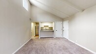 Located at 411 Annex Ave in Nashville, TN, this 1-bedroom, 2-bathroom residence offers a well-organized layout across a single floor. The living room immediately impresses with dramatic vaulted ceilings accented by exposed beams, soft carpet flooring, and elevated clerestory windows that fill the space with abundant natural light. A pass-through granite countertop connects the living area to the kitchen, creating an open, communicative flow between spaces.

The kitchen is well-appointed with crisp white shaker cabinetry, granite countertops, wood-look flooring, stainless steel appliances including a refrigerator, dishwasher, range, and microwave, plus a matte black faucet over a stainless steel sink. Ample upper and lower cabinet storage makes this kitchen as functional as it is attractive.

The generously sized primary bedroom features plush carpet, neutral toned walls, and easy access to a bathroom. Three closets throughout the unit provide excellent storage capacity. The two bathrooms are finished with clean white subway tile in the tub surrounds. A private balcony accessible via sliding glass doors from the living area extends the living space outdoors. A dedicated utility room and hallway complete this efficiently designed Nashville residence.