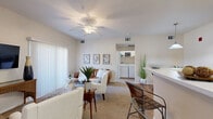 Located at 3775 W 25th St in Greeley, Colorado, this single-floor residence offers a thoughtfully designed layout with a seamless flow between living spaces. The open-concept living and dining area is anchored by a ceiling fan, vaulted ceiling accents, and plush carpeting, creating a warm and inviting atmosphere. A sliding glass door in the living room invites natural light and provides access to a private patio area. The dining space sits adjacent to a breakfast bar that connects to the galley-style kitchen, which features white cabinetry, wood-look flooring, white appliances including a refrigerator and range, and ample counter space for everyday cooking. A dedicated in-unit laundry closet houses a full-size washer and dryer, adding convenience to daily living. The bedrooms are comfortably sized with soft carpeting, vaulted ceiling details, and closet access. The primary bedroom includes a direct en-suite bathroom, which is appointed with a wide vanity, white cabinetry, a large mirror, well-lit fixtures, and a tiled tub-shower combination with wood-look flooring. The overall palette throughout the home is neutral and bright, lending a clean, move-in-ready ambiance.