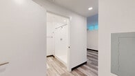 Located at 1275 N Santa Fe Dr in Denver's vibrant Santa Fe Arts District, this efficiently designed single-floor unit offers a thoughtfully laid-out living space that maximizes every square foot. The open-concept interior is finished with light wood-tone plank flooring throughout, lending a clean, contemporary feel that ties the entire space together.

The kitchen is a standout feature, showcasing sleek gray flat-front cabinetry extending from floor to ceiling, contrasted by crisp white countertops and a white tile backsplash. A full suite of stainless steel appliances — including a refrigerator, electric range, built-in microwave, and dishwasher — makes this kitchen as functional as it is stylish. Recessed lighting illuminates the space from above.

The bathroom continues the modern aesthetic with matching gray cabinetry, a white countertop vanity, wood-look plank flooring, and a walk-in tiled shower equipped with a grab bar, combining accessibility with clean design.

A bright, open living area leads to a private balcony through a floor-to-ceiling glass sliding door framed in sleek black, inviting generous natural light and providing a seamless indoor-outdoor connection. White walls and recessed lighting throughout the unit create a bright, airy ambiance well-suited for contemporary urban living.
