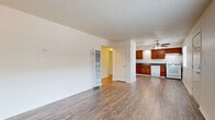 This one-bedroom, one-bathroom unit in Sacramento, CA offers a well-utilized single-floor layout with a clean, neutral aesthetic throughout. The open-concept living, dining, and kitchen area is anchored by warm hardwood-style flooring and bright white walls, creating an airy and inviting atmosphere. A wall-mounted HVAC unit and a ceiling fan with light fixture provide year-round comfort in the main living space, which also features a front entry door with a window that brings in natural light.

The kitchen is efficiently designed with rich, warm-toned cabinetry, dark granite-style countertops, and white appliances including a refrigerator, dishwasher, gas range, and oven. Ample upper and lower cabinet storage and a single-basin sink complete the functional kitchen setup.

The bedroom offers a quieter retreat with plush carpet flooring, a window with blinds overlooking greenery outside, and sufficient space for standard furnishings. Three closets throughout the unit provide generous storage options.

The bathroom features a full tub-and-shower combination with white tile surround, a window for natural ventilation, a white vanity, and hardwood-style flooring that ties back to the main living areas. A textured ceiling is consistent throughout the unit, adding a classic touch to this practical and comfortable Sacramento home.