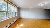 Located at 276 Saint Clair Avenue West in Toronto's sought-after midtown neighbourhood, this two-bedroom, one-bathroom unit offers a practical and well-laid-out single-floor plan. Classic parquet wood flooring flows throughout the living areas and both bedrooms, adding warmth and timeless character to the space. The generously sized primary bedroom is bathed in natural light through large windows that frame views of the surrounding greenery, and includes a sliding-door closet alongside additional storage. The second bedroom also features parquet flooring, a window with an outdoor view, and crown moulding details. The kitchen is finished in a clean, all-white palette with white cabinetry, marble-style countertops, subway tile backsplash, white tile flooring, and a window that brings in natural light. It is equipped with a full-size stove and refrigerator, along with a double stainless steel sink. The bathroom features full-surround cream tile walls, a combined tub and shower, and a window for natural ventilation. A private balcony with glass-panel railings overlooks a tree-lined streetscape, offering a serene outdoor retreat. The unit is completed by a functional hallway entryway, rounding out a well-organized and comfortable layout.