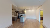 This single-story, two-bedroom, two-bathroom residence offers a thoughtfully designed open-concept layout with distinct style throughout. The living area is anchored by a dramatic vaulted ceiling with a ceiling fan, wood-look flooring, and an arched architectural detail that adds character to the space. Natural light filters in through windows, enhancing the bright, airy atmosphere.

The kitchen is a standout feature, showcasing dark gray cabinetry, granite countertops, a subway tile backsplash, and a full suite of stainless steel appliances including a refrigerator, range, and built-in microwave. A peninsula with seating provides additional prep and dining space, while pendant lighting adds a polished touch. A dedicated in-unit laundry area with a full-size washer and dryer is conveniently accessible from the kitchen.

Both bedrooms are carpeted for comfort. The primary bedroom includes a walk-in closet, while the second bedroom features a windowed wall for natural light. Each bathroom is finished with granite-topped vanities, tile flooring, and a tub/shower combination with brushed nickel fixtures, offering a clean and cohesive aesthetic throughout.