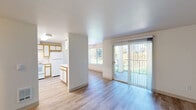 Located at 2404 Allen St. in Kelso, Washington, this well-appointed 2-bedroom, 2-bathroom single-floor home offers a functional and comfortable layout. The open-concept living and dining area is bright and inviting, featuring light hardwood-style flooring and large windows that frame lush outdoor views. A sliding glass door leads directly to a private patio, seamlessly connecting indoor and outdoor living. The kitchen is efficiently designed with white cabinetry trimmed in warm wood tones, white appliances including a dishwasher and refrigerator, a peninsula for additional counter space, and light flooring that ties the space together. Both bedrooms provide a peaceful retreat — the primary bedroom is generously sized, while both rooms feature soft carpet flooring and access to ample closet storage among the five closets throughout the home. The two bathrooms are clean and functional; one features a wide vanity with a large mirror and a tub/shower combo, while the second includes built-in shelving for added storage convenience. A dedicated laundry area, an entrance, and a hallway complete the thoughtful floor plan, making this home practical for everyday living in a serene Kelso setting.