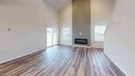 Located at 164 Meades Spring in Middletown, PA, this three-bedroom, two-bathroom home is thoughtfully laid out across three floors. The ground level houses an attached garage with an automatic opener, and a spacious unfinished basement featuring a concrete floor, insulated walls, exposed framing, and utility infrastructure — offering significant potential for future finishing.

The main living floor greets visitors with a welcoming entrance and an open-concept kitchen and living room. The living area boasts soaring ceilings, wood-look luxury vinyl plank flooring, and a sleek linear fireplace. A staircase with clean white railings anchors the space. The kitchen is outfitted with white shaker-style cabinetry, granite countertops, stainless steel appliances including a range, microwave, and refrigerator, all complemented by additional wood-look flooring.

The upper floor hosts all three bedrooms, two bathrooms, and convenient hallway access. The generously sized primary bedroom includes a walk-in closet and natural light. Additional bedrooms feature plush carpeting and windows with outdoor views. The bathrooms are finished with clean white fixtures, including a walk-in shower. Two closets and ample hallway space complete the upper level, offering practical, comfortable living throughout.