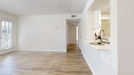 Located in Winter Park, Florida, this two-bedroom, one-bathroom home offers a well-designed single-story layout with a bright, clean aesthetic throughout. The living room is immediately impressive, boasting dramatic vaulted ceilings with a ceiling fan, a tile-surround wood-burning fireplace, and multiple windows that invite generous natural light. Light wood-style flooring flows consistently throughout the home, complementing the crisp white walls accented by a chair-rail detail.

The kitchen connects to the living area via a convenient pass-through counter with dark granite-style countertops, providing an open and interactive feel. Dark espresso cabinetry lines the galley-style kitchen, paired with stainless steel appliances including a full-size refrigerator and range. A dedicated in-unit laundry room with a full-size washer and dryer adds everyday convenience.

The two bedrooms offer comfortable proportions, with the primary bedroom providing ample space and its own closet. The second bedroom benefits from a window with natural outdoor views. The shared bathroom features a dark wood vanity with a granite-style countertop, a large mirror, and a shower-tub combination. A hallway connects the rooms efficiently, and two closets provide practical storage throughout the home.