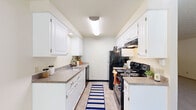 This single-floor unit offers three bedrooms, one bathroom, and a well-organized layout designed for functional living. The living room is bright and open, featuring plush carpeting, a ceiling fan, and large windows with horizontal blinds that allow generous natural light to fill the space. A textured popcorn ceiling adds a classic touch throughout the common areas.

The galley-style kitchen is efficiently designed with white cabinetry lining both walls, laminate countertops, tile flooring, and black appliances including a refrigerator, electric range with overhead exhaust, and dishwasher — providing ample storage and prep space in a compact footprint.

The primary bedroom is notably spacious, offering room for substantial furnishings, and features a sliding closet door and direct access to the bathroom. The additional two bedrooms are carpeted, each equipped with windows that bring in natural light and views of surrounding greenery, along with closet access.

The bathroom is clean and practical, featuring a single-sink vanity with white cabinetry, a tub-shower combination, and tile flooring. Throughout the unit, warm neutral tones and consistent carpeting in the bedrooms and living areas create a cohesive, understated atmosphere suited for everyday comfort.