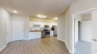 Located at 59 Anderson Ave in Canton, Georgia, this single-floor residence offers a well-designed, open-concept layout with clean, modern finishes throughout. The kitchen serves as a functional centerpiece, outfitted with white shaker-style cabinetry, granite-look countertops, a subway tile backsplash, and a full suite of stainless steel appliances including a refrigerator, electric range, microwave, and dishwasher. Wood-look luxury vinyl plank flooring runs through the main living and kitchen areas, providing a cohesive and durable surface underfoot. The open living area is bright and versatile, with ceiling fans providing additional comfort and windows fitted with blinds that allow natural light to filter in. The bedrooms feature plush wall-to-wall carpeting, ceiling fans, and generously sized windows that bring in natural light. Each bedroom also includes closet access via classic arched-panel doors. The bathroom is appointed with a wide vanity featuring white cabinetry, granite-look countertops, a large framed mirror, and wood-look flooring that ties into the overall aesthetic of the residence. The neutral color palette and consistent finishes throughout create a clean, inviting atmosphere well-suited to a variety of living arrangements.