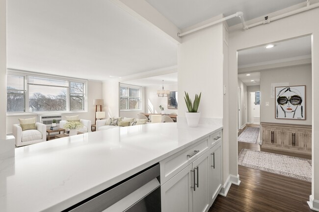 Bright and inviting living space with elegant decor, large windows, and modern quartz kitchen counter detail at Parkside Place, apartments in Cambridge, MA - Parkside Place Apartments