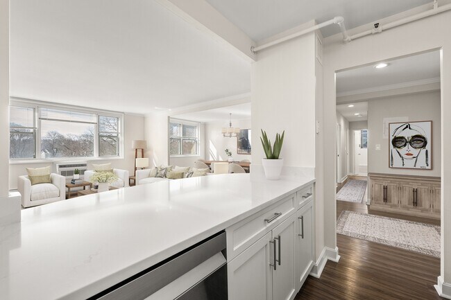 Espacio habitable luminoso y acogedor con una decoración elegante, grandes ventanales y detalles modernos de encimeras de cuarzo en la cocina en Parkside Place, apartamentos en Cambridge, MA. - Parkside Place