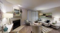 Located at 997 Johnnie Dodds Blvd in the heart of Mt. Pleasant, South Carolina, this single-floor property offers a well-designed and inviting living environment. The living room serves as a central gathering space, anchored by a classic fireplace with a tiled surround and a decorative mantle adorned with a framed mirror and accent décor. Neutral-toned walls and light-colored flooring create a bright and airy atmosphere throughout. Large windows dressed in sheer white curtains allow abundant natural light to fill the room, enhancing the open and welcoming feel. The living area is thoughtfully arranged with a plush sofa, stylish accent chairs in a patterned fabric, and a central coffee table, all tied together by a geometric area rug. Coastal-inspired artwork and teal accent pillows add a touch of color, reflecting the charm of the surrounding Lowcountry setting. The overall ambiance is warm, comfortable, and tastefully curated, making this Mt. Pleasant property an appealing space for both relaxing and entertaining.
