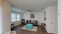This single-floor residence offers a thoughtfully designed layout that maximizes its available space across one bedroom and one bathroom. The living room serves as the centerpiece of the unit, featuring dark hardwood-style flooring, a textured ceiling, and a ceiling fan that contributes to overall comfort. Multiple windows fitted with white plantation shutters allow natural light to fill the room, creating a bright and welcoming atmosphere.

The kitchen is well-equipped with an L-shaped layout, gray raised-panel cabinetry offering ample storage, white appliances including an electric range and refrigerator, light countertops, and a window above the sink that provides additional natural light. The hardwood-style flooring continues seamlessly from the living area into the kitchen.

The bedroom is carpeted for added comfort and includes a ceiling fan, natural light from a window with shutters, and sufficient space for a full furniture arrangement. A full bathroom is accessible via the hallway and features a shower-tub combination with white tile surround. A hallway with built-in linen storage provides practical organization. The overall design is clean and neutral, lending itself well to a variety of personal styles.