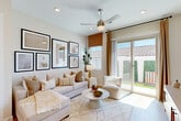 Located in Buckeye, AZ, this well-designed single-story, one-bedroom, one-bathroom home offers a thoughtfully organized layout with modern finishes throughout. The open-concept kitchen and living area serves as the heart of the home, featuring white shaker cabinetry extending to the ceiling, a white quartz countertop island with bar seating, stainless steel appliances, a subway tile backsplash, and pendant lighting. Light wood-look flooring flows seamlessly throughout, enhancing the bright, airy atmosphere. The living room is generously sized for the footprint, with large windows and a sliding glass door that floods the space with natural light and provides direct access to a private outdoor patio. A ceiling fan adds comfort to the living area. The bedroom is a calm retreat, naturally lit by a window with views to the exterior, and is complemented by a dedicated walk-in closet. The bathroom features a glass-enclosed shower, white vanity cabinetry, and warm wood-tone flooring. A separate laundry area adds everyday convenience. The overall ambiance is clean, modern, and warm—well-suited for comfortable living in the Arizona sun.