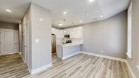 Located at 228 Park Ave in Baltimore, MD, this efficiently designed single-floor unit offers a thoughtfully laid out living space with modern finishes throughout. The open-concept kitchen is a standout feature, showcasing crisp white shaker cabinetry extending to the ceiling, a classic subway tile backsplash, and a suite of stainless steel appliances including a French door refrigerator with ice dispenser, electric range, over-the-range microwave, and dishwasher. A peninsula with a sleek quartz countertop and an undermount sink provides both additional prep space and a casual dining area, illuminated by stylish pendant lighting. The living area benefits from large, tall windows dressed with white trim that invite generous natural light and offer views of the surrounding neighborhood streetscape. Light-toned hardwood-style flooring flows seamlessly throughout, complementing the neutral gray wall palette and crisp white baseboards to create a clean, cohesive aesthetic. The bathroom is finished with a full subway-tiled walk-in shower enclosed by sliding glass doors, paired with brushed nickel fixtures for a polished, contemporary look. Overall, the space presents a well-appointed, move-in-ready interior with modern upgrades in a convenient Baltimore location.