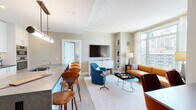 Located in Chicago's vibrant Streeterville neighborhood, this thoughtfully designed residence at 514 N Peshtigo Ct offers a seamless blend of contemporary style and urban sophistication. The entry foyer sets an inviting tone, featuring warm neutral walls, light wood-style flooring, and curated artwork that leads gracefully into the main living areas.

The open-concept living and dining space is bright and generously proportioned, anchored by floor-to-ceiling windows that frame sweeping views of the Chicago skyline and Lake Michigan. The living area features a tan leather sofa, vibrant accent chairs in teal and rust, and a built-in shelving nook, all accented by elegant sheer drapery.

The kitchen is well-appointed with crisp white cabinetry extending to the ceiling, dark stone countertops, a large center island with bar seating, stainless steel appliances including a gas cooktop and double wall ovens, and a clean glass tile backsplash.

The primary bedroom is a serene retreat with expansive city and lake views, plush carpeting, and soft, neutral tones. A secondary bedroom functions as a flexible space with a daybed and open closet system. Bathrooms are finished with herringbone-patterned tile flooring, marble-topped white vanities, and clean, modern fixtures throughout.