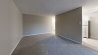 Located at 9555 SW Allen Blvd in Beaverton, Oregon, this single-floor, 3-bedroom, 1-bathroom unit offers a practical and well-organized layout. The combined dining room and kitchen is outfitted with white cabinetry, white countertops, stainless steel appliances including a refrigerator, dishwasher, and range, and light wood-style flooring that adds a clean, modern feel. The living room is generously sized, featuring plush carpet and a sliding glass door that fills the space with natural light and provides access to an outdoor area with neighborhood views. The three bedrooms are carpeted and finished in neutral tones, each with its own closet — two rooms feature sliding closet doors — and windows that bring in natural light and outdoor greenery views. The bathroom is efficiently designed with a full tub-shower combo, a single-sink vanity with white countertop, and wood-style flooring. A connecting hallway links all rooms, and textured ceilings are consistent throughout the unit. The overall aesthetic is clean and neutral, offering a move-in-ready canvas in a convenient Beaverton location.