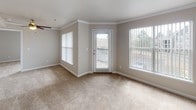Located in Castle Rock, Colorado, this single-floor residence at 2270 Castlegate Dr N offers a well-designed layout with a comfortable, neutral aesthetic throughout. The open-concept living area is a standout feature, anchored by a tile-surround fireplace and soft wall-to-wall carpeting that extends through the main living and bedroom spaces. Crown molding accents the living room, which benefits from multiple large windows fitted with vertical blinds, allowing generous natural light and views of the surrounding neighborhood. A glass panel door leads directly to an outdoor space, enhancing the connection between interior and exterior.

The kitchen is positioned adjacent to the living area via a half-wall pass-through, providing an open and connected feel. It is equipped with dark espresso cabinetry, light stone-toned countertops, stainless steel appliances including a refrigerator, microwave, and electric range, and durable wood-look flooring that carries into the hallway.

The bedrooms are generously proportioned, each with plush carpeting and large windows that invite ample daylight. The bathroom features a vanity with a granite-style countertop, dark cabinetry, wood-look tile flooring, and a full tub-shower combination with clean white tile surround and brushed nickel fixtures, rounding out a cohesive and functional interior.