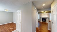 This two-floor home offers a well-considered layout with a variety of functional spaces throughout. The main level features hardwood flooring that flows through the entry corridor and into the living area, where a fireplace with a sleek surround serves as a focal point. A ceiling fan adds comfort to the living space, which benefits from natural light through blinds-fitted windows.

The kitchen is well-appointed with light wood cabinetry, dark countertops, a mosaic tile backsplash, and a full suite of stainless steel appliances, including a range, over-the-range microwave, dishwasher, and refrigerator. A peninsula with an integrated sink adds workspace and aids in defining the kitchen area.

Multiple bedrooms are found throughout the home, each fitted with ceiling fans, carpeted floors in neutral tones, and windows that allow natural light. One bedroom features a tray ceiling, adding an architectural detail that elevates the room's character.

The bathrooms include tile flooring in an earthy tone and tub-shower combinations with curved curtain rods. Natural light enters through windows fitted with blinds, and vanities with storage cabinetry provide practical functionality throughout.