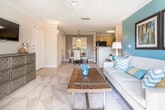 This single-floor residence in Newnan, Georgia offers a thoughtfully designed layout that balances comfort and functionality across several distinct living areas. The living room serves as a welcoming centerpiece, highlighted by a vibrant teal accent wall, a ceiling fan, and French doors flanked by windows that invite abundant natural light and outdoor views. Soft carpeting and a textured ceiling complete the relaxed yet polished atmosphere.

Adjacent to the living area, the dining space features crown molding, a pendant light fixture, and direct access to additional storage via a closet. The galley-style kitchen is efficiently arranged with light wood cabinetry, speckled countertops, tile flooring, and black appliances, offering a practical and clean workspace.

The residence includes two bedrooms, each with plush carpeting and distinct character. One bedroom showcases a bold terracotta accent wall, while the other features soft blue-green tones and a large window that fills the room with natural light. Both offer ample space for furnishings and storage.

Two full bathrooms are finished with tile flooring, granite-style vanity countertops, and tub-shower combinations with decorative curtains, maintaining a consistent and clean aesthetic throughout the home.