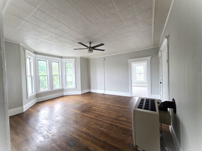 Large living room with wood floors higher ceilings and oversized windows - 357 Central St