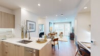 Located at 2800 Brighton Blvd in Denver's vibrant RiNo neighborhood, this thoughtfully designed two-bedroom, three-bathroom residence offers a modern open-concept layout with warm wood-tone flooring and abundant natural light throughout. The kitchen flows seamlessly into the dining and living areas, featuring light wood cabinetry, a stainless steel appliance suite, a waterfall-edge island with an undermount sink, and sleek white countertops. A marble-topped dining table anchors the space between the kitchen and a bright, airy living room, where floor-to-ceiling windows frame sweeping city views. The primary bedroom provides a serene retreat with a ceiling fan, generous closet space, and a well-appointed en-suite bathroom showcasing large-format marble-style tile flooring, a floating vanity, wall-mounted cabinetry, and a glass-enclosed walk-in shower. The second bedroom also enjoys abundant natural light and city views. Two additional full bathrooms are finished with the same elegant tile and contemporary fixtures. A dedicated hallway with two closets adds practical storage. The space blends clean architectural lines with warm, upscale finishes to create a cohesive and inviting urban living environment.