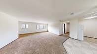 Located at 6172 S 31st St in Greenfield, Wisconsin, this single-floor, one-bedroom, one-bathroom unit offers a practical and comfortable layout. The open living room is generously sized, featuring warm beige carpet, crisp white walls, and multiple windows that allow natural light to fill the space. The living area flows seamlessly toward the kitchen, which is appointed with dark wood cabinetry, white appliances including a refrigerator and range, a stainless steel sink, and light tile flooring — providing a functional and efficient cooking space with ceiling fan overhead. The bedroom is a comfortable size, carpeted to match the living area, and benefits from two windows offering views of the surrounding neighborhood. A large bifold closet provides ample storage. The full bathroom features a vanity with a marble-style countertop, white cabinetry, a tub/shower combination, and classic mosaic tile flooring. Throughout the unit, the clean white walls and neutral tones create a bright, versatile atmosphere ready for personalization. This well-laid-out unit offers straightforward, functional living in a residential Greenfield neighborhood.