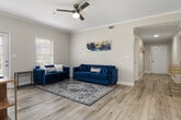 This well-appointed single-floor residence offers six bedrooms and four full bathrooms, providing generous space for a variety of living arrangements. Light-toned luxury vinyl plank flooring flows throughout the main living areas and hallways, while plush carpet adds warmth to the bedrooms. The open kitchen is a standout feature, outfitted with crisp white shaker cabinetry, stone countertops, a subway tile backsplash, and a full suite of stainless steel appliances including a refrigerator, dishwasher, range, and built-in microwave. A dedicated laundry area is conveniently accessible directly from the kitchen. The living room is bright and welcoming, benefiting from multiple windows that invite natural light and provide views to the exterior. Crown molding adds a refined architectural touch to the space. The bedrooms are comfortably sized, with the primary bedroom offering built-in shelving and a sense of calm with its neutral palette and natural light. The bathrooms feature white vanities with stone-topped counters, tub-shower combinations, and wood-look tile flooring. Three connecting hallways ensure smooth circulation throughout the home, completing a functional and cohesive floor plan.