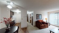 Located at 2312 Hampden Ave in Saint Paul, Minnesota, this single-floor unit offers a thoughtfully arranged layout that balances functional living spaces with a comfortable, residential feel. The open-concept design connects the kitchen, dining, and living areas, creating a cohesive flow throughout the main living zone.

The kitchen is equipped with rich, dark espresso cabinetry extending from floor to ceiling on both sides, providing ample storage. Light countertops contrast the cabinetry, and the space includes a double stainless steel sink and white refrigerator. Wood-style flooring runs through the kitchen and dining area, lending warmth and durability underfoot.

The dining area sits just off the kitchen near the entry, featuring a ceiling fan with integrated lighting and a textured ceiling overhead. A dedicated hallway leads to the private bedroom and bathroom, maintaining a clear separation between living and sleeping spaces.

The living room is carpeted and generously sized, anchored by a large sliding glass door with vertical blinds that allows natural light to fill the space. A wall-mounted air conditioning unit serves the room alongside baseboard heating.

The bedroom is comfortably proportioned with carpet flooring, a window with vertical blinds, and baseboard heating. The bathroom features a tub-shower combination and tile flooring, completing this functional and well-organized unit.