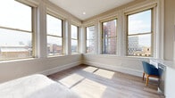 Located on Orange Street in the heart of Providence, Rhode Island, this thoughtfully designed studio offers a seamless blend of modern finishes and urban convenience. The open-plan layout maximizes the sense of space, with light wood-look flooring flowing throughout and neutral warm tones creating a clean, contemporary ambiance.

Large double-hung windows with classic white trim fill the space with abundant natural light and frame sweeping views of Providence's downtown skyline. A dedicated sleeping area features a striking blue geometric accent wall, adding a bold design element alongside warm wood furniture and generous closet access.

The compact yet fully equipped kitchenette includes white cabinetry, a stainless steel refrigerator, microwave, dishwasher, and a single-basin sink — providing everyday functionality in a streamlined footprint. A wall-mounted flat-screen TV and built-in desk area complete the living zone.

The private bathroom is finished with large-format tile flooring, floor-to-ceiling neutral wall tile in the shower/tub combination, a floating wood vanity with a white countertop, and modern chrome fixtures. The overall design maintains a consistent, hotel-inspired aesthetic throughout.

This well-appointed urban studio offers a comfortable and stylish base in one of Providence's most walkable downtown neighborhoods.