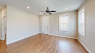 Located at 1718 Fairbanks Dr in Barling, Arkansas, this single-story home offers a thoughtfully designed layout across two bedrooms and two bathrooms. The open-concept living room and kitchen area is anchored by warm wood-look flooring, recessed lighting, and ceiling fans that run throughout the home. Natural light filters in through white-shuttered windows, enhancing the bright, neutral color palette on every wall.

The kitchen is a standout feature, showcasing white shaker cabinetry, granite countertops, a central island, and a full suite of stainless steel appliances including a range, microwave, dishwasher, and French door refrigerator. A matte black faucet adds a modern contrast to the undermount sink.

Both bathrooms are notably designed with accessibility in mind, featuring floor-to-ceiling marble-look tile, open walk-in showers with matte black grab bars and handheld showerheads, granite-topped white vanities, and gold-accented mirrors.

The bedrooms are comfortably sized, each equipped with ceiling fans, recessed lighting, and natural light from windows. The primary bedroom offers a generous footprint. A dedicated laundry area includes a stacked washer and dryer unit alongside white cabinetry and granite countertops, rounding out this efficiently designed home.