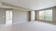 Located at 5639 Scioto Crest Dr in Columbus, Ohio, this single-floor, one-bedroom, one-bathroom residence offers a thoughtfully organized layout with a neutral, modern aesthetic throughout. The open-concept living and kitchen area serves as the heart of the home, featuring warm hardwood-style flooring in the kitchen and plush carpet in the living space. The kitchen is well-equipped with white shaker-style cabinetry, dark granite countertops, a white subway tile backsplash, and a full suite of black appliances including a range, microwave, and refrigerator. A dedicated in-unit laundry area with stacked washer and dryer is conveniently accessible directly from the kitchen. The spacious living room is bathed in natural light from large windows and offers direct access to a private patio, extending the living space outdoors. The bedroom features soft carpet, multiple windows with outdoor views, and connects to a full bathroom finished with tile flooring, a dark wood vanity, and a walk-in shower. Three closets, including a generously sized walk-in closet outfitted with wire shelving systems, provide ample storage. Warm gray walls and clean white trim create a cohesive, move-in-ready environment throughout.