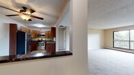This single-floor residence offers a thoughtfully designed layout that balances functionality and comfort throughout its living spaces. The kitchen is a standout feature, showcasing rich medium-toned wood cabinetry, dark granite countertops, tile flooring, and a full suite of stainless steel appliances including an electric range, over-the-range microwave, and refrigerator. A breakfast bar provides a convenient transition into the adjacent living area. The open-concept living space is generously sized, finished with neutral-toned wall-to-wall carpeting and a ceiling fan, creating a bright and airy atmosphere. A column detail adds architectural interest and helps delineate the kitchen from the main living area. The bedroom features plush carpeting, a window that brings in natural light, and a spacious walk-in closet with built-in wire shelving on both sides, offering exceptional storage. The bathroom is well-appointed with tile flooring, beige wall tile surrounding the soaking bathtub and shower combination, a wood vanity, and chrome grab bars for added accessibility and safety. Throughout, the space maintains a consistent, clean aesthetic with textured ceilings and warm neutral tones.