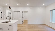 Located at 901 Leland St in Philadelphia's Fairmount neighborhood, this thoughtfully designed 2-bedroom, 1-bathroom unit offers a clean, modern aesthetic throughout its efficiently laid-out single floor. Light hardwood flooring and crisp white walls run continuously through the space, creating a bright and cohesive feel.

The open-concept kitchen and living area serves as the heart of the unit. The kitchen is outfitted with white shaker cabinets, a marble-style tile backsplash, quartz countertops, stainless steel appliances including a refrigerator, range, and microwave, and a central island with a built-in sink and stylish pendant lighting overhead.

Both bedrooms are finished with the same light hardwood floors and recessed lighting. The primary bedroom offers a comfortable footprint, while the second bedroom features a window with natural light. Each bedroom includes access to closets, and the unit provides a total of four closets throughout, ensuring ample storage.

The bathroom is a standout feature, showcasing a full tub and shower combination with dramatic marble-look tile surround, matte black fixtures and hardware, and coordinating marble-style tile flooring. The unit also includes an in-unit laundry area, adding everyday convenience to this well-appointed Philadelphia residence.