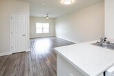 Located on N Country Club Drive in Montgomery, Alabama, this single-floor unit offers a thoughtfully designed open-concept layout that promotes a sense of spaciousness and ease of flow. The living area features warm wood-style flooring and a ceiling fan, creating a comfortable and inviting atmosphere, with a window dressed in blinds that allows for controlled natural light.

The kitchen is a functional centerpiece of the home, equipped with rich dark cabinetry, light countertops, a double-basin stainless steel sink, and a full suite of white appliances including a refrigerator, electric range, built-in microwave, and dishwasher. The kitchen opens directly to the living area, making it ideal for everyday living and entertaining.

The hallway connects the main living spaces to the private areas of the unit, where multiple doors lead to well-sized rooms. Each bedroom features the same wood-style flooring, neutral walls, and windows that bring in natural light while maintaining privacy. The bathroom is finished with tile flooring, a wide vanity featuring dark cabinetry and a white countertop, a large mirror, and a shower-tub combination. Grab bars are also present, adding a practical touch. Throughout the unit, clean white trim and neutral tones create a cohesive and move-in-ready aesthetic.