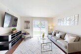 Located at 140 Helle Blvd in Dundee, Michigan, this thoughtfully designed 2-bedroom, 1-bathroom residence offers a functional single-floor layout that maximizes every square foot. Rich hardwood flooring flows throughout the home, creating a warm and cohesive aesthetic.

The living room is bright and welcoming, anchored by a large sliding glass door that floods the space with natural light and opens to an outdoor view. A floating media console and neutral color palette give the area a clean, modern feel.

The kitchen features warm honey-toned cabinetry, granite countertops with a decorative tile backsplash, a breakfast bar with seating, and black appliances including a refrigerator, range, and built-in microwave. It connects seamlessly to a hallway leading to the rest of the home, with the dining area nearby.

The spacious primary bedroom offers a dedicated window with exterior views, providing ample natural light. The second bedroom functions well as a guest room or home office, complete with a closet. Three closets are distributed throughout the unit for generous storage.

The bathroom includes a granite-topped vanity with warm wood cabinetry and a large mirror. In-unit laundry adds everyday convenience. The home's clean lines, modern finishes, and efficient layout make it a comfortable and practical residence.