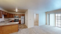 Located at 7420 Steubenville Pike in Oakdale, PA, this single-floor, 2-bedroom, 1-bathroom residence offers a practical and well-designed layout. The kitchen is a standout feature, equipped with warm wood cabinetry, light granite-style countertops, and a full suite of stainless steel appliances including a refrigerator, electric range, over-the-range microwave, and dishwasher. A peninsula counter provides additional workspace and serves as a natural divider between the kitchen and the open living area, which is finished with plush wall-to-wall carpeting. The primary bedroom is generously sized and includes a walk-in closet with built-in shelving and hanging rods, offering excellent storage. The second bedroom features soft carpeting and a window that lets in natural light, making it suitable as a guest room or home office. The full bathroom is finished with tile flooring, a single vanity with a mirror and lighted fixture, a glass-enclosed shower, and accessibility-friendly grab bars. Neutral tones throughout the home create a clean, move-in-ready aesthetic that is easy to personalize.
