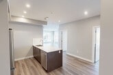 Located at 11450 80 Ave NW in Edmonton's desirable South Campus neighbourhood, this well-appointed 3-bedroom, 2-bathroom unit offers a thoughtfully designed single-level layout with modern finishes throughout. Light-toned laminate flooring runs seamlessly through the open-concept living and kitchen areas, complemented by neutral grey walls and recessed pot lighting. The kitchen is a standout feature, boasting a large island with a white quartz countertop, dark wood cabinetry, stainless steel appliances, a subway tile backsplash, and a pendant light fixture — ideal for both cooking and entertaining. The living area flows naturally from the kitchen, with large windows framing views of the surrounding neighbourhood. The spacious primary bedroom features oversized windows on two walls, filling the room with natural light and offering open city views. The additional bedrooms are well-sized, each with their own windows and access to closets. The two bathrooms are finished to a contemporary standard — one featuring an illuminated vanity mirror, dark wood cabinetry, and a walk-in shower, while the second includes a soaker tub with marble-style tile surround. Four closets, a dedicated laundry area, and a connecting hallway complete this efficiently organized home.