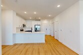 Located at 113 Hominy Ridge Ct in Asheville, NC, this thoughtfully designed 2-bedroom, 2-bathroom home offers a clean, modern aesthetic across a single floor. Light hardwood flooring runs throughout the entire space, complementing the crisp white walls and recessed lighting that create a bright, welcoming atmosphere.

The open-concept kitchen and living area serves as the heart of the home. The kitchen is outfitted with white shaker-style upper cabinets, navy lower cabinetry, a classic white subway tile backsplash, and a generous quartz-topped island with an undermount sink and matte black faucet. Stainless steel appliances—including a French door refrigerator, microwave, dishwasher, and range—complete the modern setup. The adjacent living area receives abundant natural light through large windows and a glass door that opens to an outdoor space.

The primary bedroom is a well-proportioned retreat featuring dual windows with outdoor views and a ceiling fan. It connects to a sleek en-suite bathroom with a double-sink vanity, large mirror, and a frameless glass walk-in shower. Three closets, including a walk-in with wire shelving, provide generous storage throughout. The second bedroom is bright and versatile, ideal as a guest room or home office. The single-floor layout ensures seamless flow and accessibility throughout the entire home.
