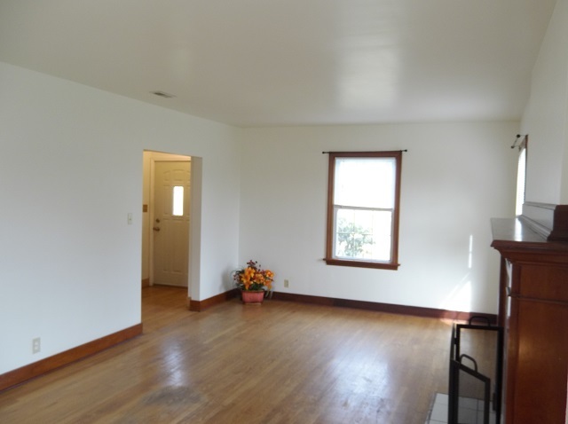 Entry door to living room, hardwood floors, wood trim and newer windows. - 742 E Ford Ave