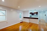 Located at 63 Forest Hill in Newark, NJ, this one-bedroom, one-bathroom unit offers a well-organized, single-floor layout that makes efficient use of its cozy footprint. Warm hardwood flooring runs throughout the main living areas and bedroom, lending a classic character to the space.

The combined kitchen and living area serves as the heart of the unit. The kitchen is well-appointed with rich dark wood cabinetry, white quartz countertops, marble-look tile flooring, and stainless steel appliances including a gas range and full-size refrigerator. A window above the radiator brings in natural light, creating a bright and functional cooking space.

The living area flows naturally from the kitchen, featuring polished hardwood floors, recessed lighting, and windows that provide views of the surrounding greenery. The bedroom is a comfortable, well-proportioned room with the same warm hardwood floors, a closet, a window with outdoor views, and a radiator for heating.

The bathroom is a standout feature, showcasing floor-to-ceiling marble-look tile surrounding a full soaking tub with an overhead shower. A window provides natural ventilation, and the dark vanity complements the elegant tilework. A hallway and entrance area complete the thoughtfully designed layout of this Newark residence.