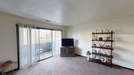 Located at 4284 Hidden Hills Dr in Kalamazoo, Michigan, this single-floor residence offers a well-organized layout designed for comfortable everyday living. The living room is a welcoming, carpeted space bathed in natural light streaming through large sliding glass doors that open onto a private balcony, providing pleasant outdoor views. The room offers generous space for seating and entertainment, with a textured ceiling adding a classic touch. The kitchen is equipped with ample white cabinetry trimmed in dark wood, a double-basin sink with a pass-through window, a dishwasher, an electric range, and a full-size refrigerator, all set atop durable hardwood-style flooring. The bedroom is a comfortable, carpeted retreat featuring a spacious closet with bifold doors and convenient access to an adjacent bathroom. Two bathrooms serve the residence: one featuring a bathtub and shower combination with a vanity and mirror, and a second with hardwood-style flooring and a toilet and vanity. Throughout the home, neutral wall tones and consistent flooring choices create a cohesive, understated ambiance that is both practical and inviting.
